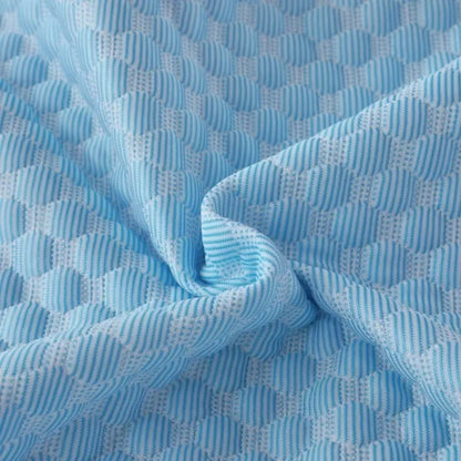Close-up of the blue diamond-quilted ice-silk fabric, twisted to show its texture and sheen.