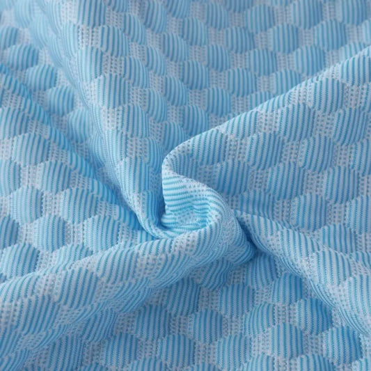 Close-up of the blue diamond-quilted ice-silk fabric, twisted to show its texture and sheen.